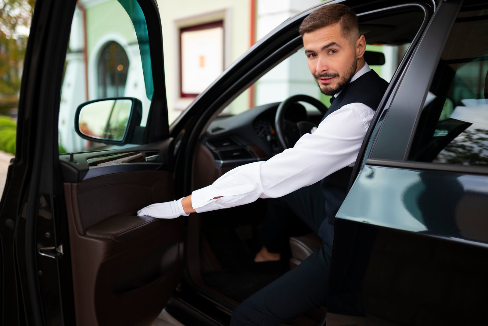 Chauffeur's hands resting on a leather steering wheel